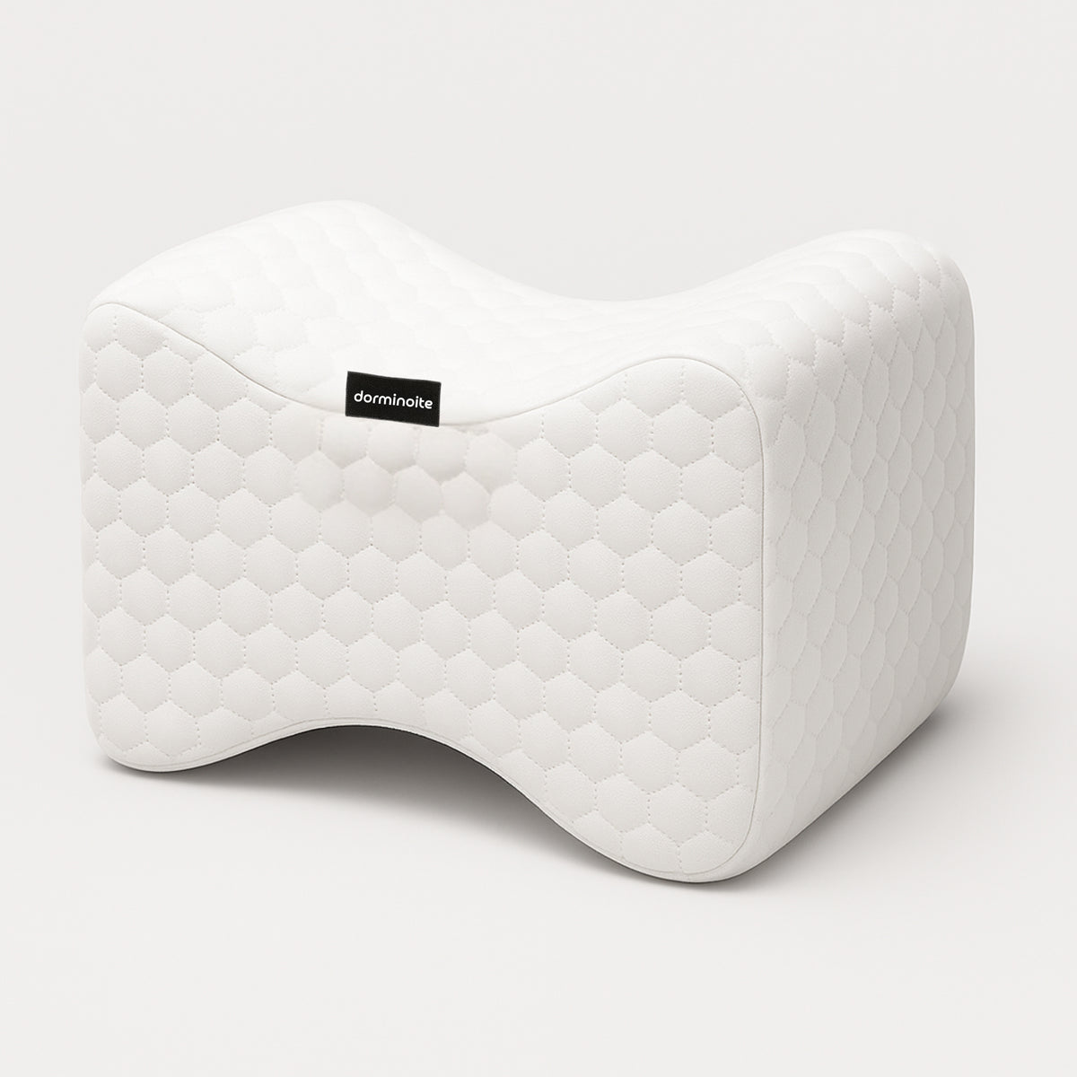 lmohada ortopédica para piernas Dorminoite, con diseño ergonómico en forma de mariposa y tejido acolchado blanco, sobre fondo neutro.